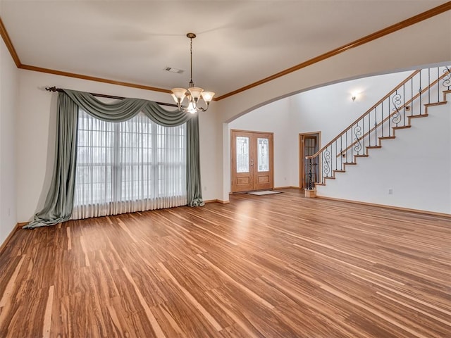 1419 W Royal Oaks Rd, Pauls Valley, OK 73075 - unfurnished living room featuring wood finished floors, crown molding, arched walkways, stairway, and a chandelier