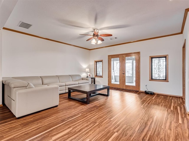 living room with wood-type flooring, french doors, crown molding, and ceiling fan