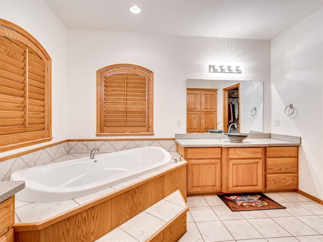 bathroom featuring tile patterned flooring, a bath, and vanity