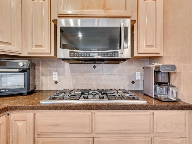 1419 W Royal Oaks Rd, Pauls Valley, OK 73075 - kitchen featuring stainless steel appliances, light brown cabinets, dark countertops, and backsplash