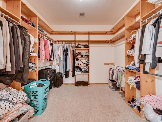 walk in closet featuring light carpet