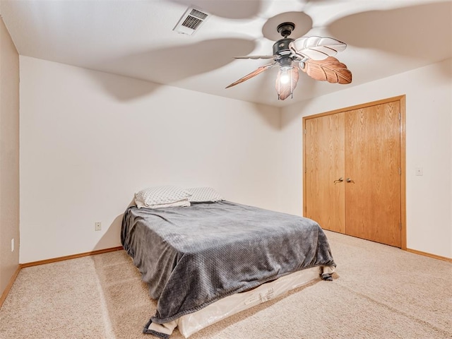 carpeted bedroom with ceiling fan and a closet