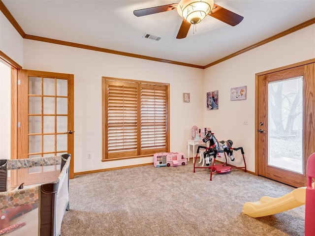 recreation room with ceiling fan, carpet floors, and ornamental molding