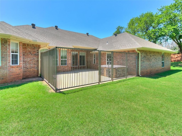 back of house with a patio and a lawn