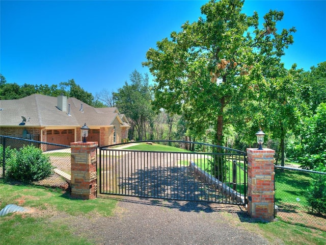 view of gate with a lawn and a garage