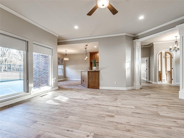 unfurnished living room featuring ceiling fan with notable chandelier, light wood-type flooring, and crown molding