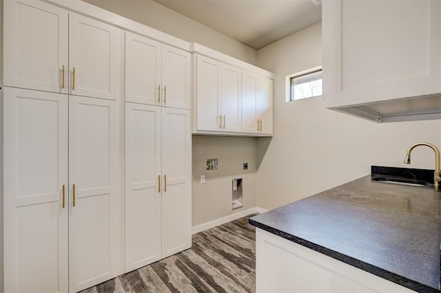 washroom with hookup for an electric dryer, cabinets, dark wood-type flooring, and hookup for a washing machine