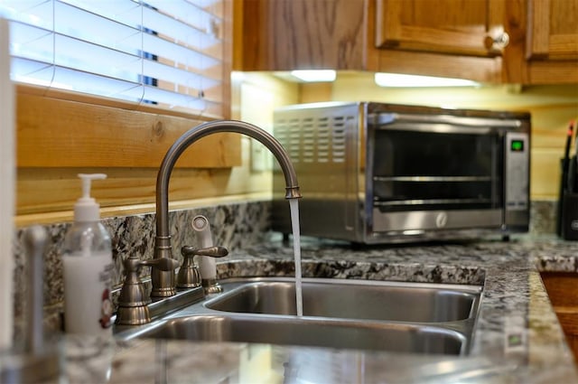 interior details with stone countertops and sink