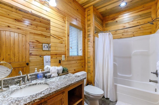 full bathroom featuring wooden walls, shower / bath combo with shower curtain, vanity, and toilet