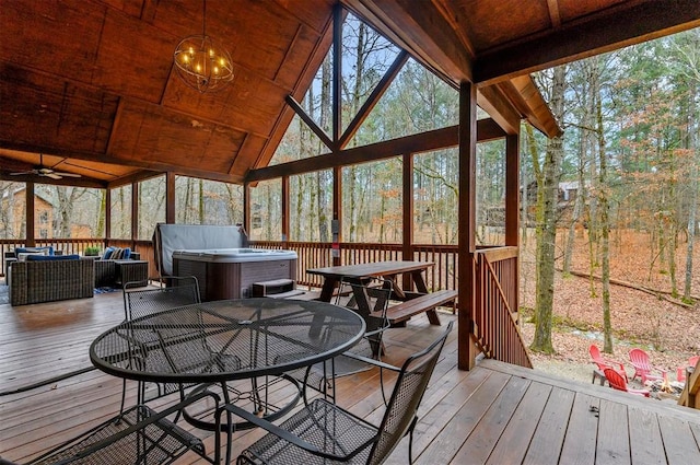 sunroom / solarium with ceiling fan, plenty of natural light, and vaulted ceiling