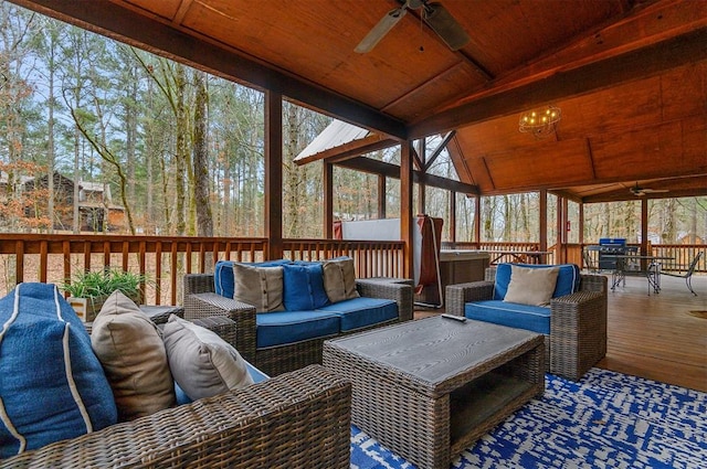 wooden terrace with area for grilling, ceiling fan, and outdoor lounge area