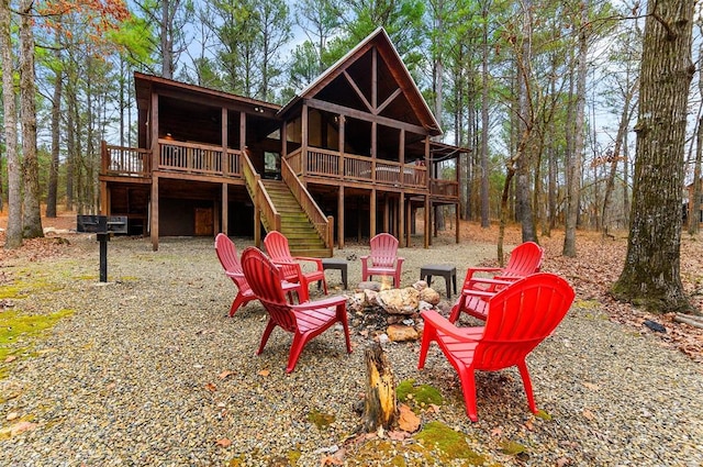 back of house featuring an outdoor fire pit and a wooden deck