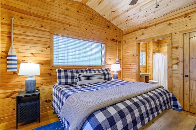 bedroom with hardwood / wood-style floors, wooden walls, and vaulted ceiling