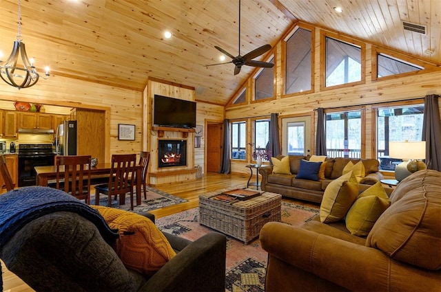 living room featuring plenty of natural light, light wood-type flooring, and high vaulted ceiling