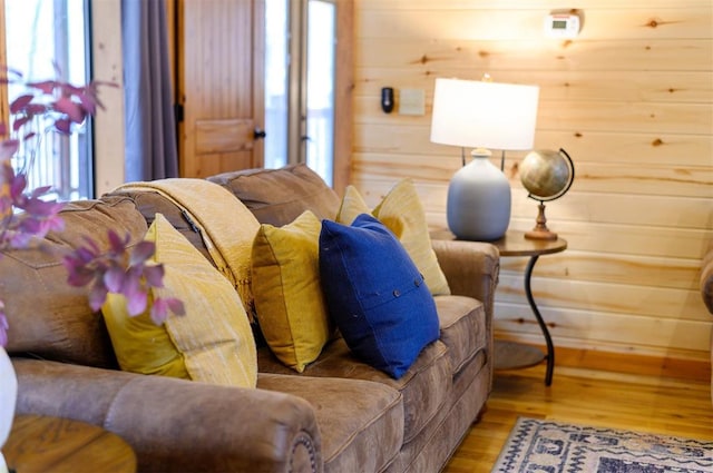 living room featuring wooden walls and light hardwood / wood-style flooring