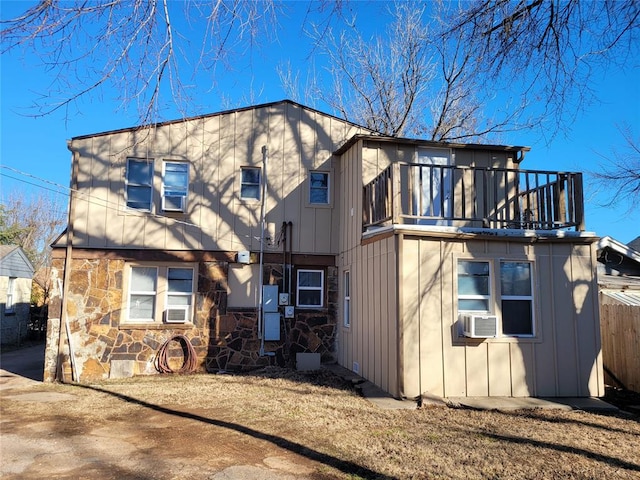 rear view of property featuring a balcony and cooling unit