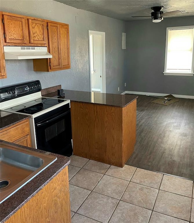 kitchen featuring light tile patterned floors, white electric range, kitchen peninsula, and exhaust hood