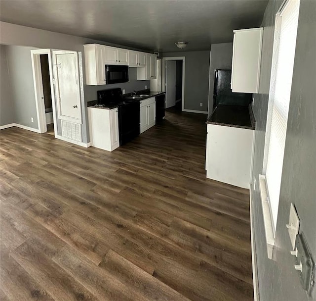 kitchen with dark wood-type flooring, white cabinets, black appliances, and sink