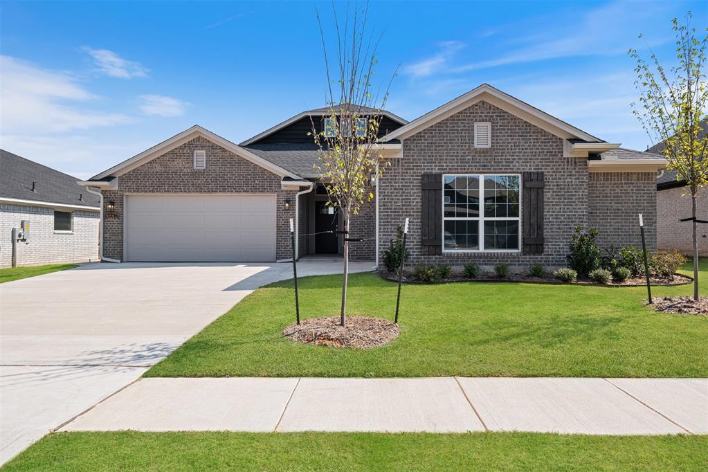 13256 Sawtooth Oak Rd, Choctaw, OK 73020 - view of front of house with an attached garage, driveway, a front yard, and brick siding