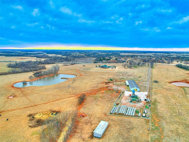 aerial view at dusk with a water view and a rural view