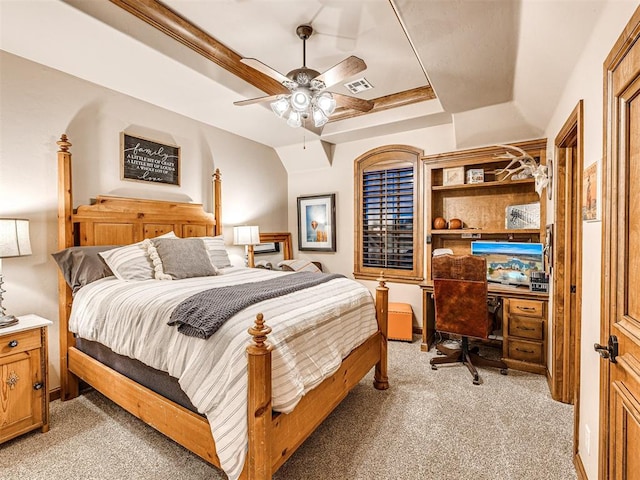 carpeted bedroom featuring a tray ceiling and ceiling fan