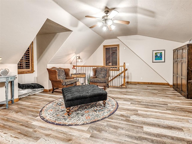 sitting room with lofted ceiling, ceiling fan, and wood-type flooring