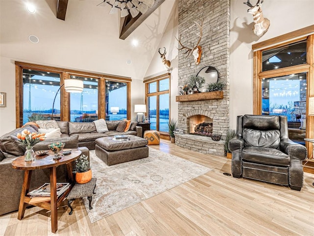 living room featuring a stone fireplace, light hardwood / wood-style flooring, and high vaulted ceiling