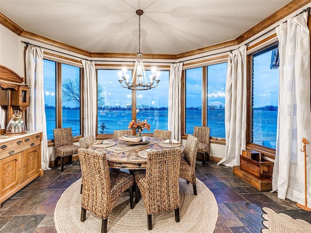 dining room featuring a wealth of natural light, crown molding, and a water view