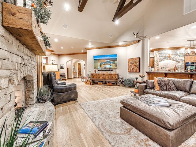 living room featuring crown molding, a fireplace, high vaulted ceiling, and light hardwood / wood-style floors