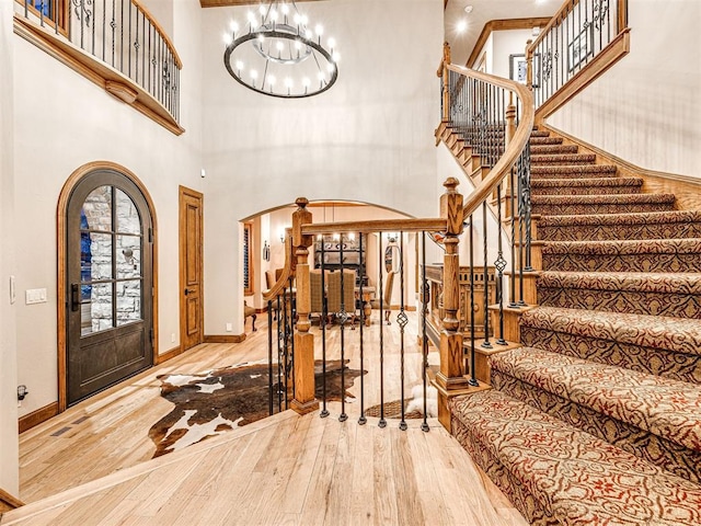 foyer featuring wood-type flooring, a high ceiling, and a chandelier