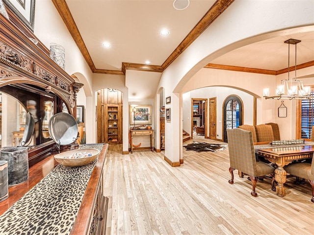 interior space featuring a notable chandelier, light hardwood / wood-style floors, and ornamental molding