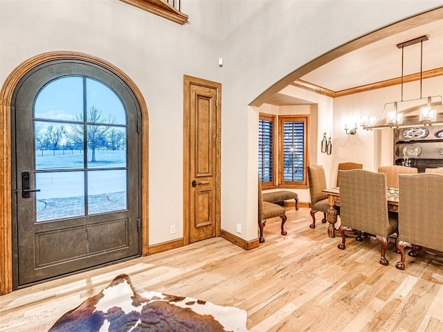 entrance foyer featuring light hardwood / wood-style floors, an inviting chandelier, and crown molding