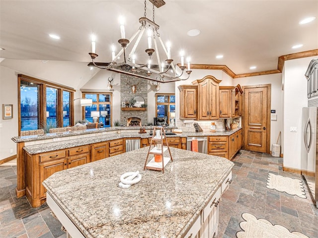 kitchen featuring kitchen peninsula, a spacious island, an inviting chandelier, a fireplace, and hanging light fixtures