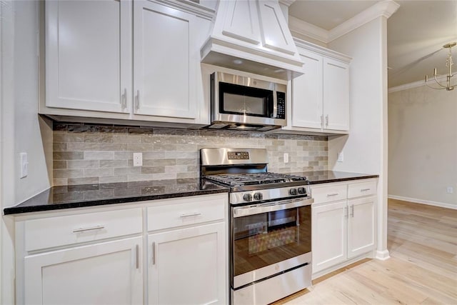 kitchen with backsplash, ornamental molding, stainless steel appliances, light hardwood / wood-style flooring, and white cabinets