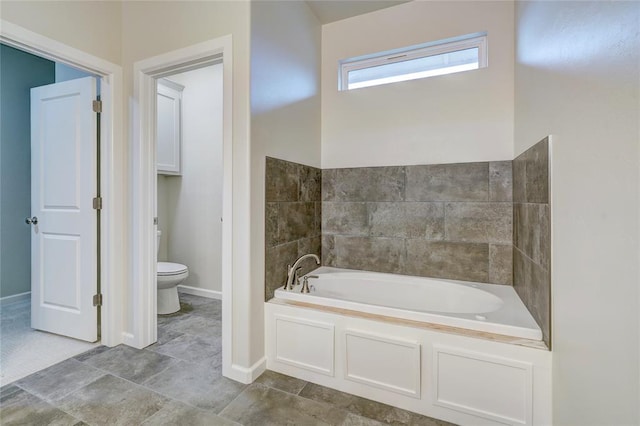 bathroom featuring a tub to relax in and toilet