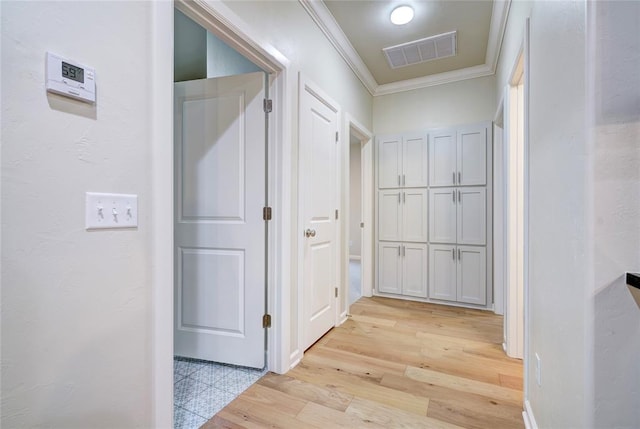 hallway with light hardwood / wood-style floors and ornamental molding