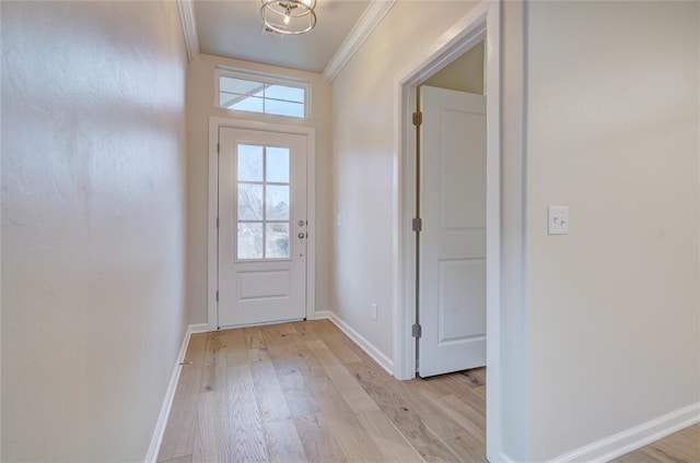 doorway with a notable chandelier, light wood-type flooring, and ornamental molding