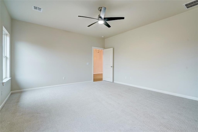 empty room featuring ceiling fan and light colored carpet