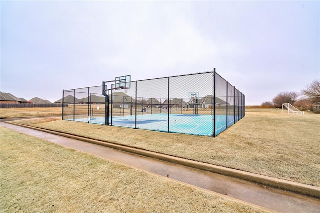 view of sport court with a lawn