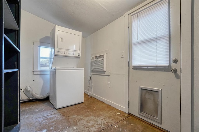 clothes washing area with an AC wall unit and stacked washer / drying machine