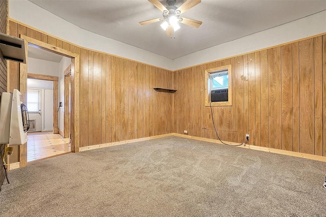 spare room with cooling unit, ceiling fan, carpet floors, and wood walls