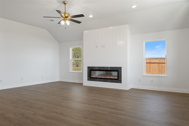 unfurnished living room with dark hardwood / wood-style flooring, a large fireplace, vaulted ceiling, and ceiling fan