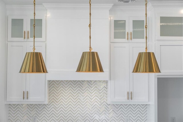 details featuring white cabinets, pendant lighting, and crown molding