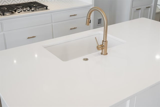 room details with sink, white cabinets, and stainless steel gas stovetop