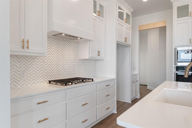 kitchen with white cabinets, backsplash, dark wood-type flooring, and custom exhaust hood