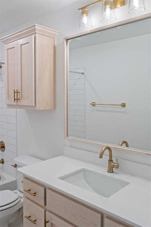 full bathroom featuring vanity, tiled shower / bath combo, and toilet