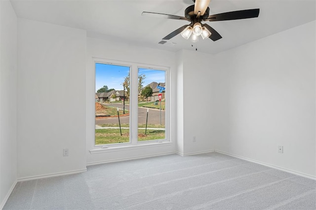 empty room featuring ceiling fan and light colored carpet