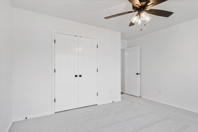 unfurnished bedroom featuring ceiling fan, a closet, and light carpet