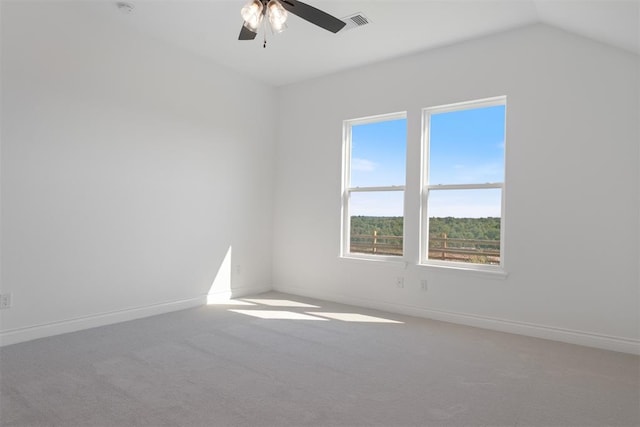 carpeted spare room featuring ceiling fan and vaulted ceiling