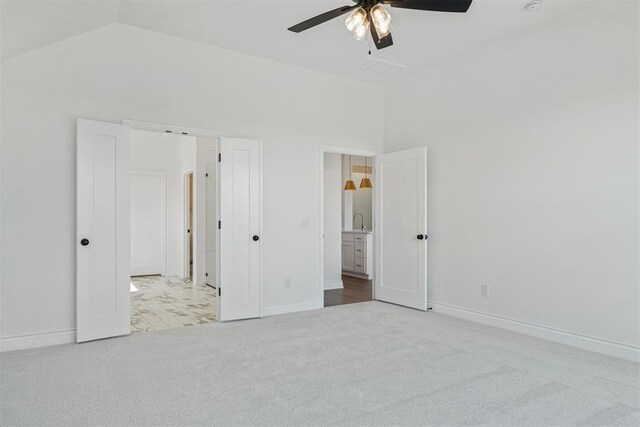 unfurnished bedroom featuring ceiling fan, sink, light carpet, and high vaulted ceiling